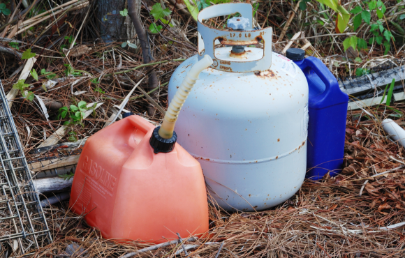 A jerry can and propane tank are sitting on a skid